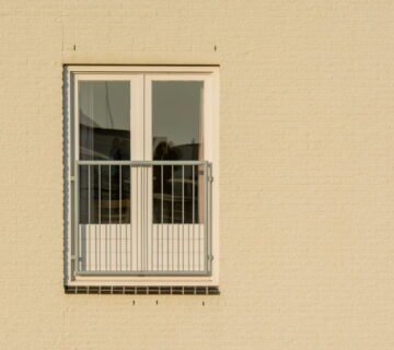 Raam met balkon in een beige gevel